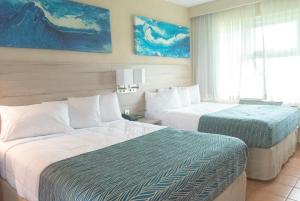 Habitación de hotel con 2 camas y ventana en Punta Borinquen Resort en Aguadilla