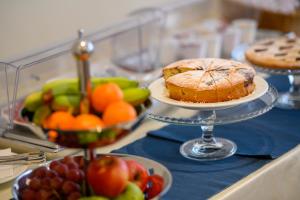 een tafel met fruitschalen en een taart bij La Collina Hotel & Spa in Oliveto Citra