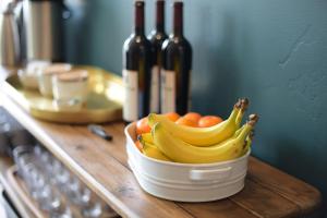 a bowl of bananas and oranges on a counter with wine bottles at Spoke and Vine Motel in Palisade