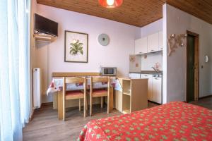 フォルガリーアにあるAlaska Clubresidenceのテーブル付きの部屋、ベッド付きのキッチンが備わる客室です。