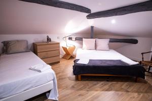 a bedroom with two beds and a wooden floor at Le Clos St Louis in Ax-les-Thermes