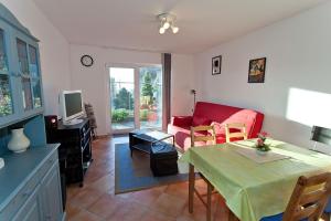ein Wohnzimmer mit einem Tisch und einem roten Sofa in der Unterkunft Ferienwohnung in Sassnitz RÜGEN Nähe Weltnaturerbe Kreideküste in Sassnitz