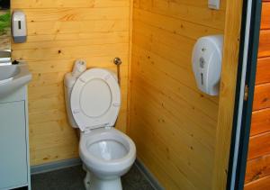 a bathroom with a toilet in a wooden wall at Osada Indiańska in Ostrów Podlaski +28 photos