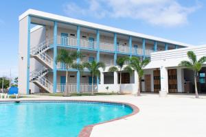 un hôtel avec une piscine en face d'un bâtiment dans l'établissement Punta Borinquen Resort, à Aguadilla