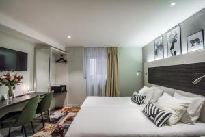 a hotel room with a bed and a desk at Hôtel Couvent du Franciscain Centre ville in Strasbourg