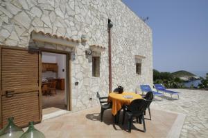 a table and chairs in front of a stone building at Baia Di Campi in Vieste