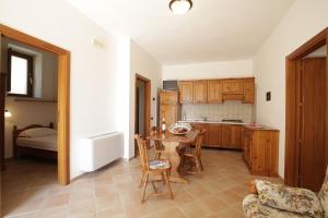 a kitchen with a table and chairs and a bed at Baia Di Campi in Vieste
