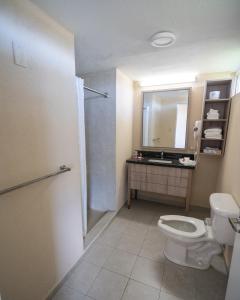 a bathroom with a toilet a sink and a shower at Punta Borinquen Resort in Aguadilla