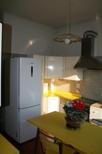 una cucina con tavolo e frigorifero bianco di Stop and Go a Olgiate Comasco