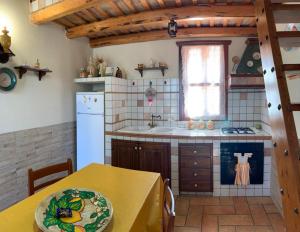eine Küche mit einem Tisch und einem gelben Tischtuch in der Unterkunft Baglio Cracchiolo Casa Baldo in San Vito lo Capo