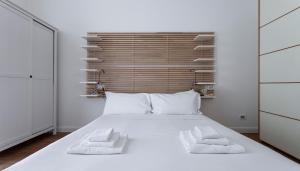 ein Schlafzimmer mit einem weißen Bett mit zwei Handtüchern darauf in der Unterkunft Italianway - Rosales 3 B in Mailand