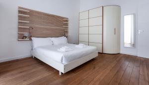 Schlafzimmer mit einem großen weißen Bett und Holzböden in der Unterkunft Italianway - Rosales 3 B in Mailand