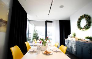 a dining room with a table and yellow chairs at Apartamenty 242 in Toruń