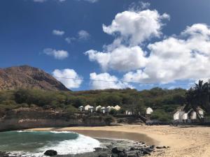 una spiaggia con un gruppo di case sullo sfondo di Apartamentos DECOR a Tarrafal