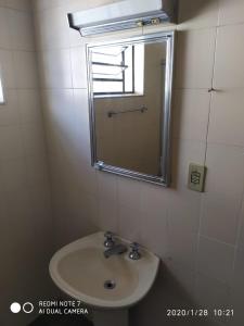 a bathroom with a sink and a mirror at Hostel da Moda in Passos