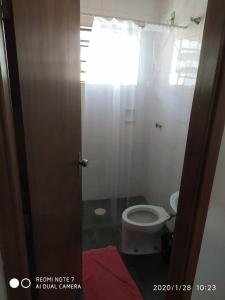 a bathroom with a toilet and a window at Hostel da Moda in Passos