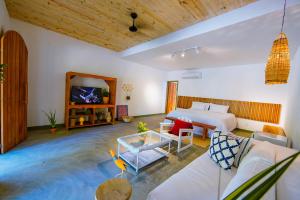 a room with a bed and a couch and a tv at Quadrado Pousada in São Miguel dos Milagres