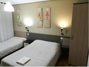 Posteľ alebo postele v izbe v ubytovaní Pension Santiago