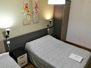 a hotel room with two beds and a lamp at Pension Santiago in Burgos