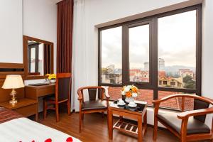 a hotel room with a bed and a table and chairs at Diamond Hotel in Ninh Binh