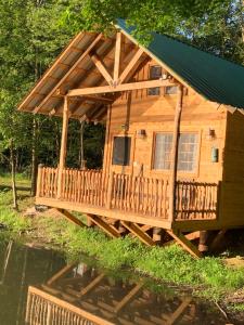 a log cabin with a deck on the water at Blue Lodge in Hesston