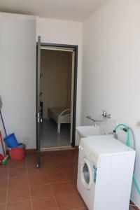 a bathroom with a washing machine and a sink at Villeta Laura in Baia verde in Il Monte