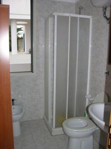 a bathroom with a white toilet and a sink at Villeta Laura in Baia verde in Il Monte +6 photos