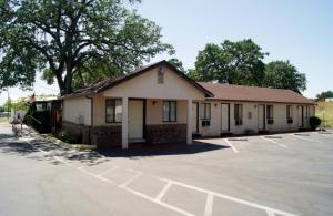 un edificio con un estacionamiento delante de él en Travelers Motel, en Cottonwood