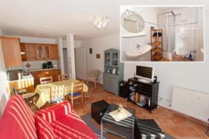 a living room with a red couch and a kitchen at Ferienwohnung in Sassnitz RÜGEN Nähe Weltnaturerbe Kreideküste in Sassnitz +57 photos