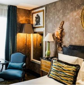 een slaapkamer met een bed, een stoel en een lamp bij Hôtel Chateaubriand in Parijs