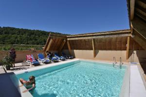 a woman is swimming in a swimming pool at Best Western Le Pont d'Or in Figeac