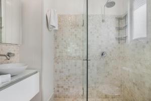 a bathroom with a glass shower with a sink at Contemporary Cottage in Perfect Lifestyle Address in Brisbane