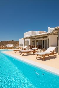 a villa with a swimming pool next to a house at Margi Villas in Mikonos