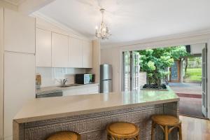 a kitchen with a large island with stools at Contemporary Cottage in Perfect Lifestyle Address in Brisbane