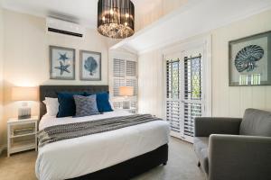 a bedroom with a bed and a couch and a chair at Contemporary Cottage in Perfect Lifestyle Address in Brisbane