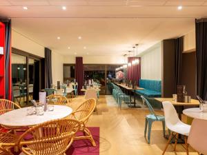 une salle à manger avec des tables, des chaises et une table dans l'établissement ibis Tours Sud, à Chambray-lès-Tours