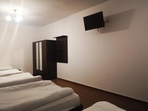 una fila de camas alineadas en una habitación en Pokoje o wysokim standardzie, en Słupsk