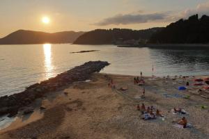 a group of people on a beach at sunset at THE GALLERY in La Spezia