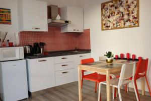 a kitchen with white cabinets and a table and chairs at THE GALLERY in La Spezia