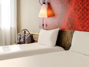 a hotel room with two beds and a lamp at ibis Bordeaux Centre - Gare Saint-Jean in Bordeaux