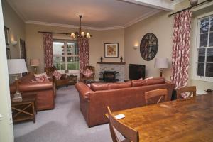 sala de estar con mesa y muebles de cuero marrón en Bakers Rest ideal for 2 families centrally located in Grasmere with walks from the door, en Grasmere