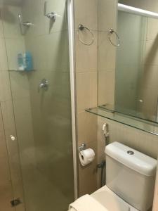 een badkamer met toilet en glazen douche bij Flat Beira-Mar Landscape in Fortaleza