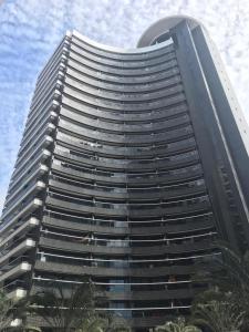 een hoog gebouw met palmbomen ervoor bij Flat Beira-Mar Landscape in Fortaleza