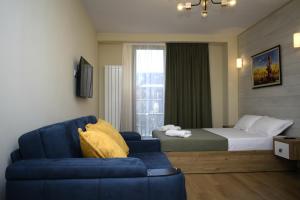 ein Hotelzimmer mit einem Bett und einem blauen Sofa in der Unterkunft New Gudauri, Red Co, Loft 1 in Gudauri