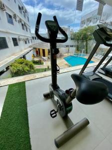 a gym with a treadmill and a swimming pool at Scaini Palace Hotel in Arroio do Silva