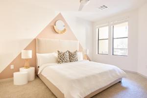 a white bedroom with a large bed with a pointed headboard at Sonder at Hance Park in Phoenix