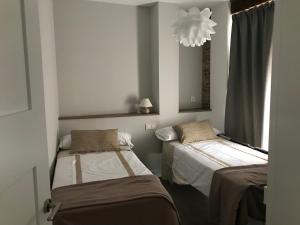 A bed or beds in a room at Apartamentos DUKE