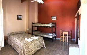 een slaapkamer met 2 bedden in een kamer met rode muren bij Hotel Atlántico Residencial in Santa Teresita +33 foto's