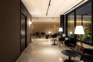 a lobby with a waiting room with chairs and tables at Hotel Raval House in Barcelona