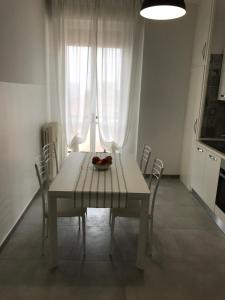 einen weißen Esstisch mit Stühlen und eine Schale Obst in der Unterkunft B&Bononia View in Bologna